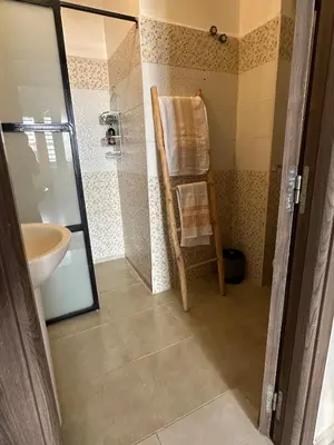 a bathroom with a wooden chair and a sink at A flat near the airport in Marrakech