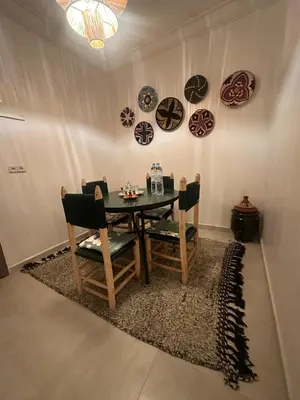 a dining room with a table and chairs and plates on the wall at A flat near the airport in Marrakech