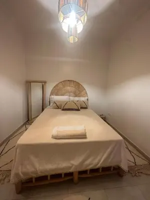 a bedroom with a large bed with a chandelier at A flat near the airport in Marrakech