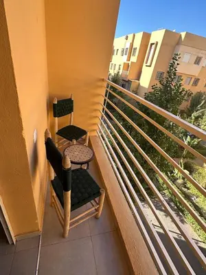 two chairs and a table on a balcony at A flat near the airport in Marrakech