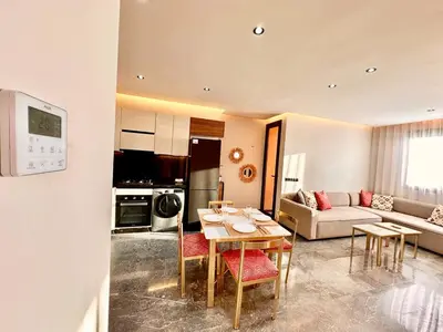 a kitchen and living room with a table and chairs at Cozy and Spacious Apartment, Free Parking in Marrakech