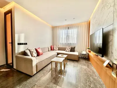a living room with a couch and a flat screen tv at Cozy and Spacious Apartment, Free Parking in Marrakech