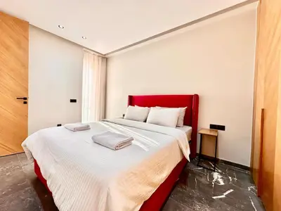 a bedroom with a large bed with a red headboard at Cozy and Spacious Apartment, Free Parking in Marrakech