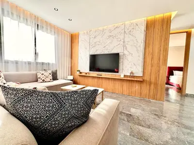 a living room with a couch and a tv at Cozy and Spacious Apartment, Free Parking in Marrakech