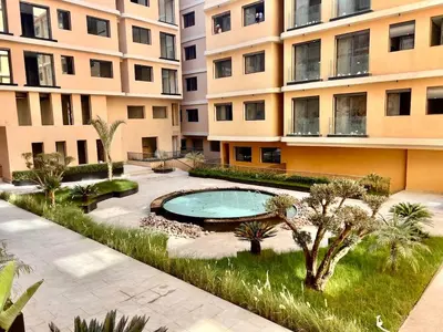 an apartment building with a swimming pool in the yard at Cozy and Spacious Apartment, Free Parking in Marrakech