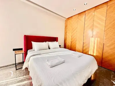 a bedroom with a large bed with a red headboard at Cozy and Spacious Apartment, Free Parking in Marrakech
