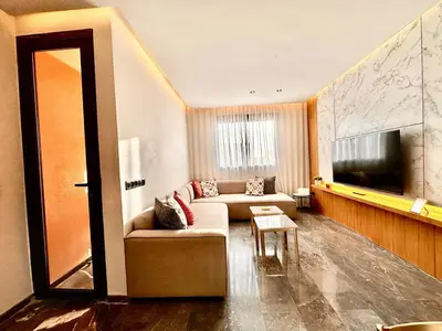 a living room with a couch and a flat screen tv at Cozy and Spacious Apartment, Free Parking in Marrakech