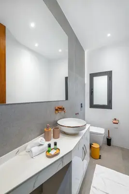 a white bathroom with a sink and a mirror at Villa Anzar Refined Oasis wChef and Emerald Hammam in El Rhechat