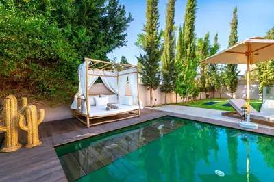 a swimming pool with a swing and an umbrella at Villa Anzar Refined Oasis wChef and Emerald Hammam in El Rhechat