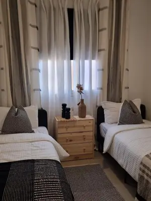 a bedroom with two beds and a dresser and a window at Bohemian & Moroccan Apartment Close to Airport & Medina in Marrakech