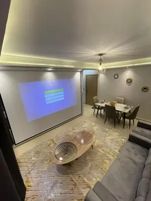 a living room with a projection screen and a table at Vivez le rêve dans un appartement F4 moderne in Marrakech