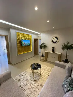 a living room with a couch and a painting on the wall at Vivez le rêve dans un appartement F4 moderne in Marrakech