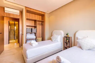 two beds in a room with white sheets at Apartment with swimming pool in Marrakech