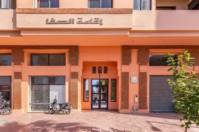 an orange building with a motorcycle parked outside of it at Apartment with swimming pool in Marrakech