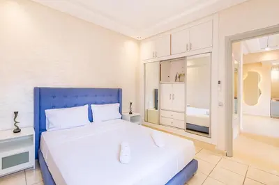 a bedroom with a large bed with a blue headboard at 2 chambres dans la ville rouge in Douar Bellouk