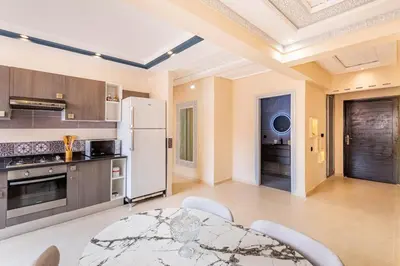 a kitchen with a table and a white refrigerator at 2 chambres dans la ville rouge in Douar Bellouk