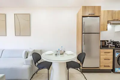 a living room with a white table and a refrigerator at Escapade intime en ville rouge in Marrakech
