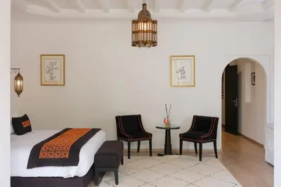 a bedroom with a bed and two chairs and a table at Villa Yali in Marrakech