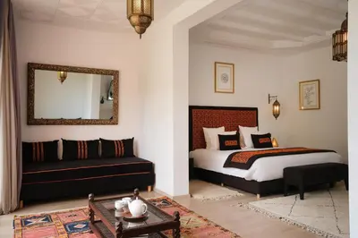 a bedroom with a bed and a couch and a mirror at Villa Yali in Marrakech