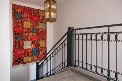 a staircase with a rug on the wall and a chandelier at Villa Yali in Marrakech