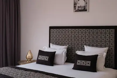a bedroom with a bed with black and white pillows at Villa Yali in Marrakech
