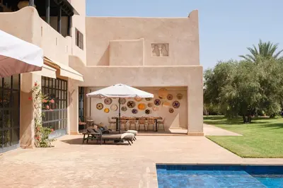 a house with a patio with a table and an umbrella at Villa Monica in Marrakech