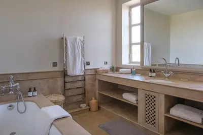 a bathroom with a tub and a large mirror at Villa Monica in Marrakech