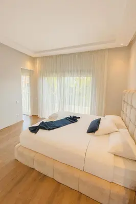 a large bed in a bedroom with a large window at Villa 4 Suites with Pool, near Hivernage in Marrakech