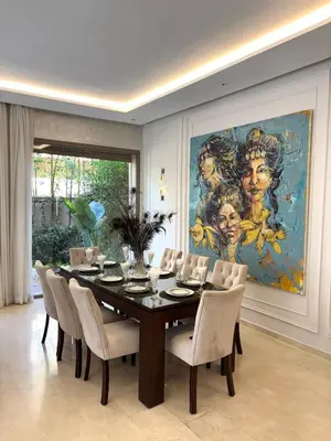 a dining room with a table and chairs and a painting at Villa 4 Suites with Pool, near Hivernage in Marrakech