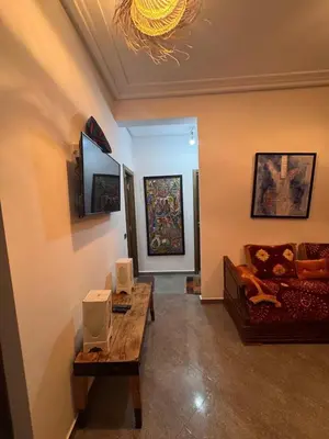 a living room with a couch and a table with speakers at appartement lumineux familial, vue sur l'océan avec wifi rapide in Marrakech