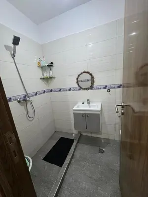a bathroom with a sink and a shower with a mirror at appartement lumineux familial, vue sur l'océan avec wifi rapide in Marrakech
