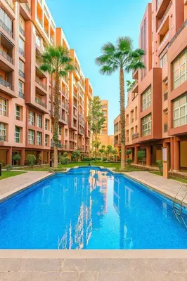 a swimming pool with palm trees and buildings at Gueliz 3BR 3BA Duplex Pool & Balcony Majorelle in Marrakech
