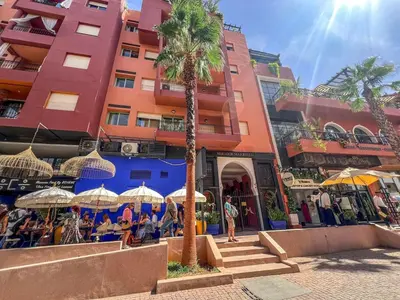 a group of people sitting under umbrellas in front of a building at Gueliz 3BR 3BA Duplex Pool & Balcony Majorelle in Marrakech