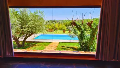 a window with a view of a swimming pool from a house at Villa Deneb - secret garden, swimming pool and starry sky in Marrakech