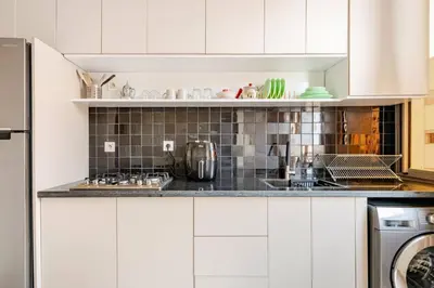 a kitchen with white cabinets and a stove top oven at Idéal Famille Neuf - Fibre Optique - 7 min Guéliz in Marrakech