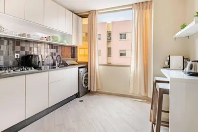 a kitchen with white cabinets and a washer and dryer at Idéal Famille Neuf - Fibre Optique - 7 min Guéliz in Marrakech
