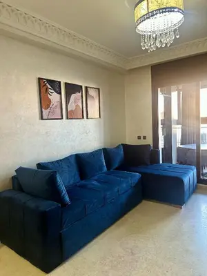 a blue couch in a living room with a chandelier at studio équipé et centrale -Guéliz in Marrakech