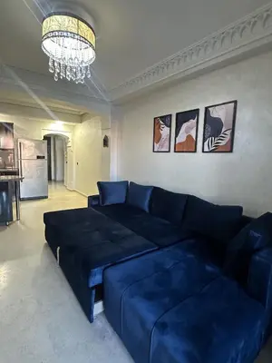 a living room with a blue couch and a chandelier at studio équipé et centrale -Guéliz in Marrakech
