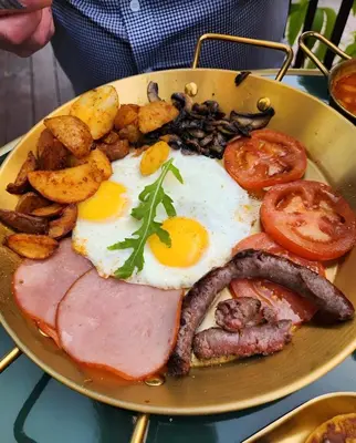 a plate of breakfast food with eggs sausage and potatoes at studio équipé et centrale -Guéliz in Marrakech