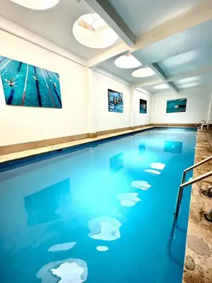 a swimming pool with blue water in a room at studio équipé et centrale -Guéliz in Marrakech