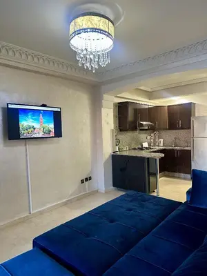 a living room with a blue bed and a kitchen at studio équipé et centrale -Guéliz in Marrakech