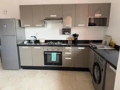 a kitchen with a stove and a sink and a refrigerator at Beautiful apartment in Premium Village Marrakech in Marrakech