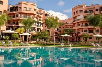 a swimming pool in front of a building at Beautiful apartment in Premium Village Marrakech in Marrakech