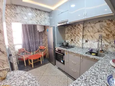 a kitchen with granite counter tops and a table at AU GC Gueliz Cosy in Marrakech