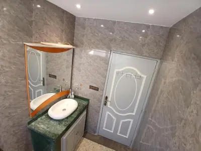 a bathroom with a sink and a mirror and a door at AU GC Gueliz Cosy in Marrakech