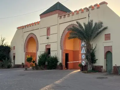 a building with a palm tree in front of it at La perle de la palmeraie in Marrakech