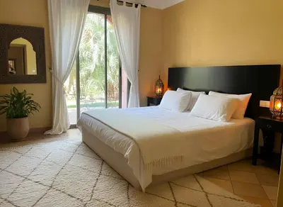 a bedroom with a large bed and a large window at La perle de la palmeraie in Marrakech