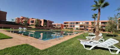 a resort with a swimming pool with two lawn chairs at Domaine de noria in Marrakech