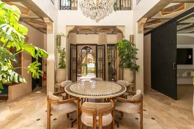 a dining room with a table and chairs and a chandelier at Riad azzouina in Marrakech