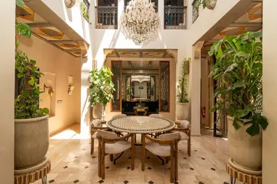 a dining room with a table and chairs and a chandelier at Riad azzouina in Marrakech